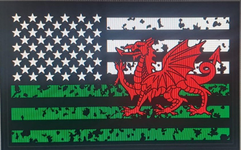 Flag with a red Welsh dragon over black, white, and green stripes