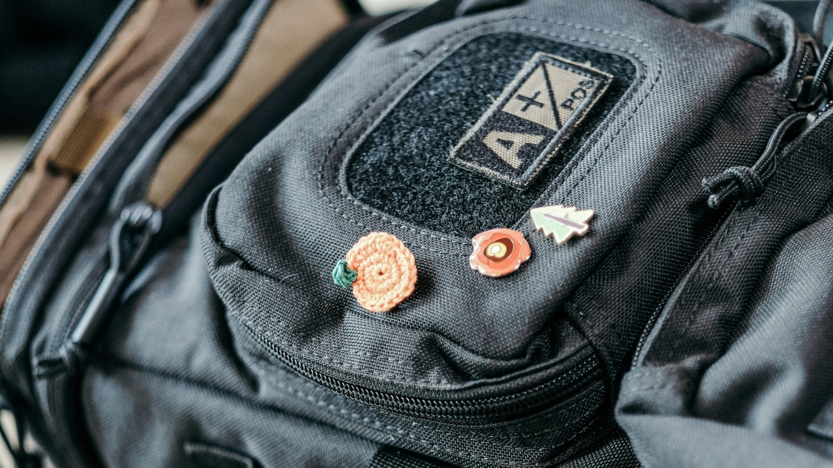 A close-up image of a black backpack featuring a fabric patch