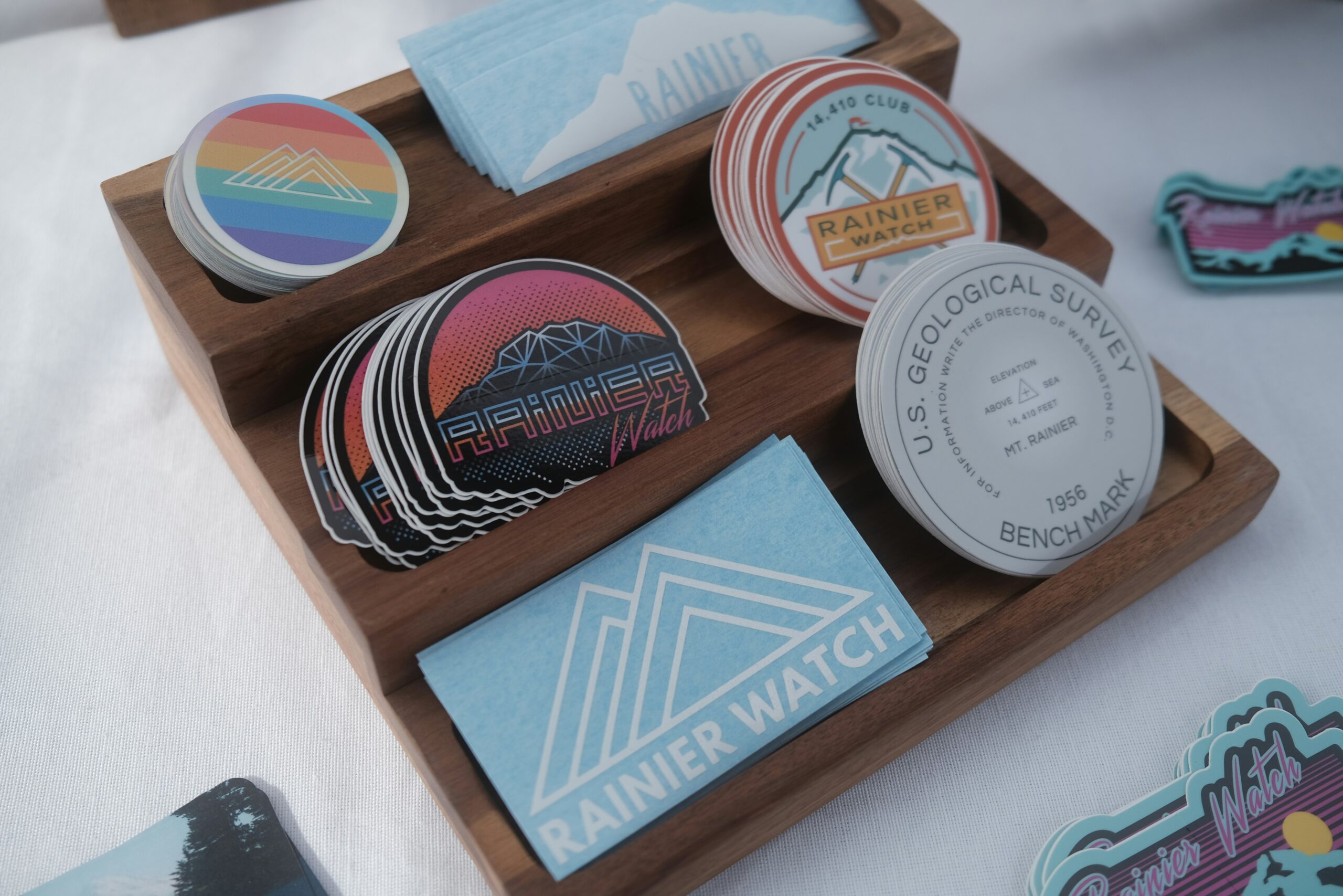 A wooden display tray featuring an assortment of colorful patches