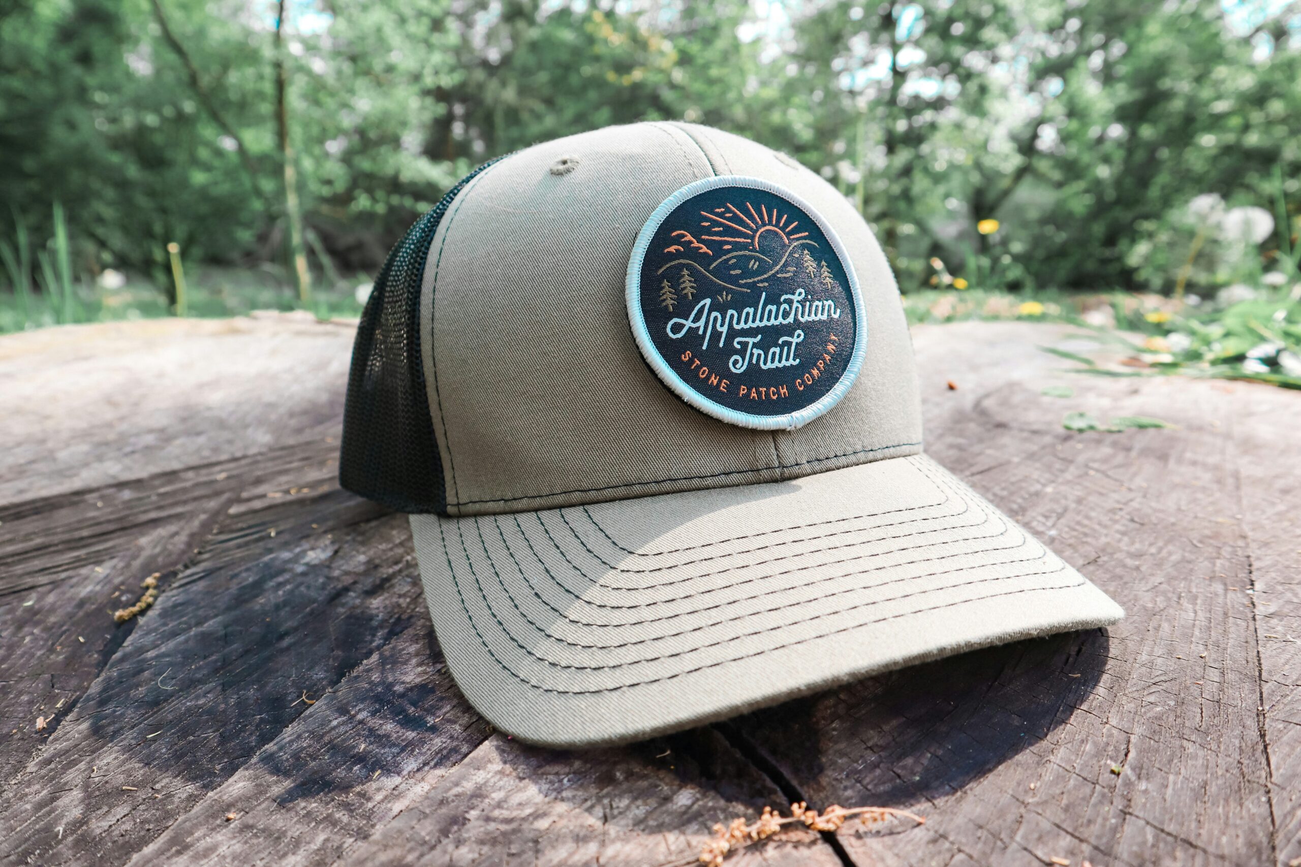 A khaki-colored trucker hat featuring a round patch