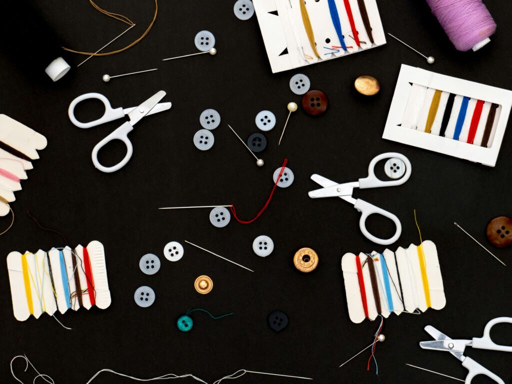Buy custom patches concept image showing scissors, threads, needles, and sewing accessories used for making patches